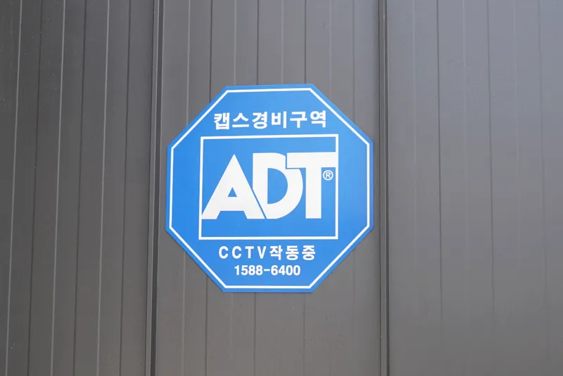 주차장 벽에 붙은 ADT캡스 경비구역 표지